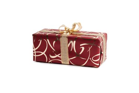 packaged rectangular gift in burgundy packaging with gold bow and gold pattern on a white backgroundの写真素材