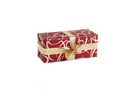 packaged rectangular gift in burgundy packaging with gold bow and gold pattern on a white backgroundの写真素材