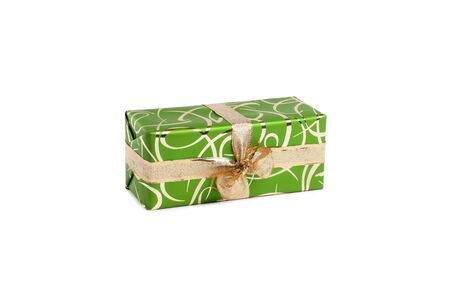 packaged rectangular gift in green packaging with gold bow and gold pattern on a white backgroundの写真素材