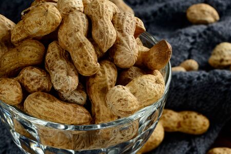 Peanuts in a bowl on a dark background. Peanuts in a shell. Healthy food.の写真素材