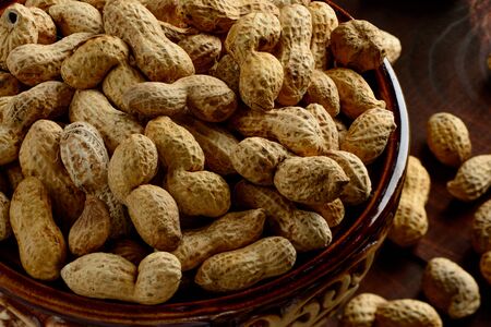 Peanuts in a bowl on a dark background. Peanuts in a shell. Healthy food.の写真素材