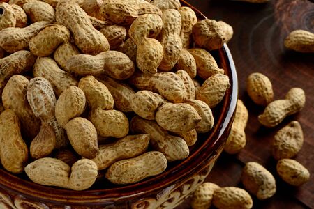 Peanuts in a bowl on a dark background. Peanuts in a shell. Healthy food.の写真素材