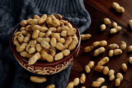 Peanuts in a bowl on a dark background. Peanuts in a shell. Healthy food.の写真素材
