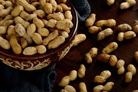 Peanuts in a bowl on a dark background. Peanuts in a shell. Healthy food.の写真素材