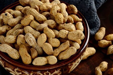 Peanuts in a bowl on a dark background. Peanuts in a shell. Healthy food.の写真素材