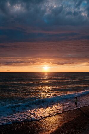 sunset at sea. waves and a cloudsの写真素材