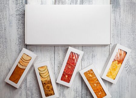 Boxes of fruit chips lie on a white wooden backgroundの写真素材