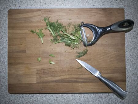 Fennel leaves on the wood board cut with a knife