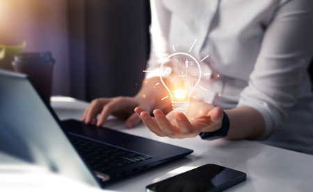 Businessman hand holding glowing light bulb in office. Business idea concept. 3D Renderingの写真素材