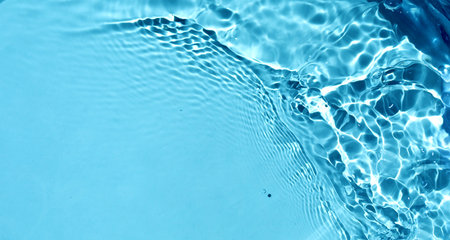 closeup of water surface with waves and ripples on blue background