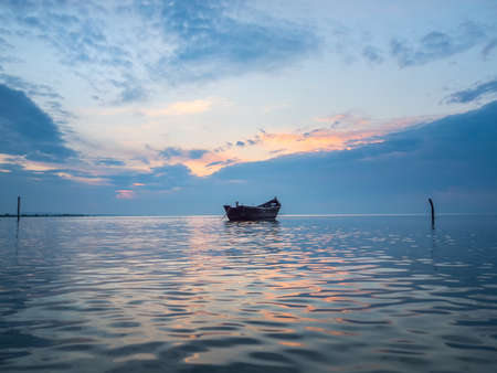 Beautiful morning landscape with a boat on the lake at the sunrise, Razelm Lake, Sarichioi, Romaniaの写真素材