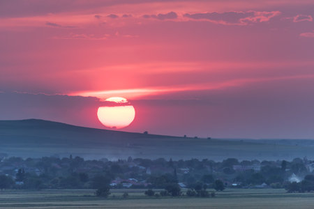 Beautiful rural landscape with a big setting sun, Dobrogea, Romaniaの写真素材