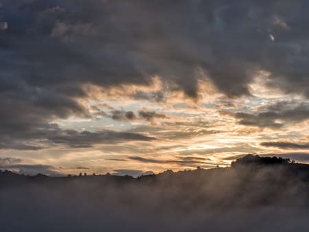 Beautiful sunrise light over the peaks of the mountains with trees silhouettes, Fundatura Ponorului, Hunedoara County, Romaniaの写真素材