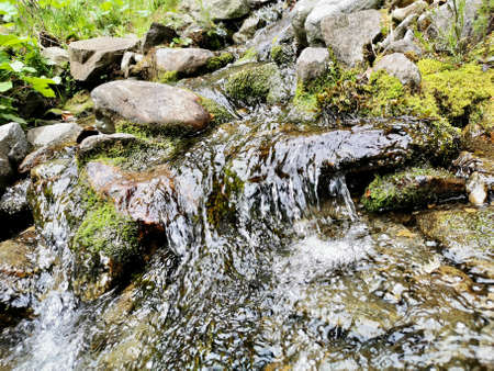 Landscape with the flowing river and stones in frontの写真素材