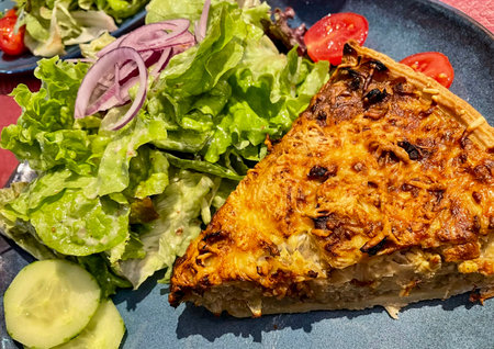 Piece of cake with meat accompanied by a healthy salad