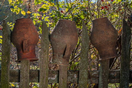 Three clay pitchers on the wooden fence. Three buddies. Clay pitchers.の写真素材