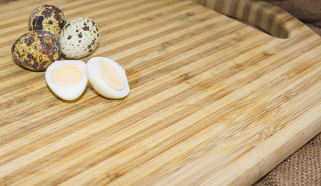 Hard boiled quail egg halves with egg shells on wooden board, photographed with natural light Selective Focusの写真素材