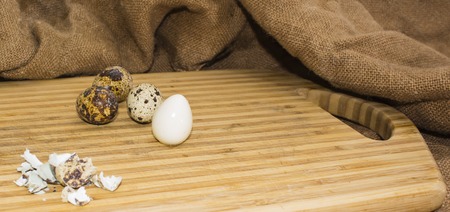 Hard boiled quail egg halves with egg shells on wooden board, photographed with natural light Selective Focusの写真素材