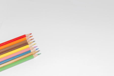 Blank paper and colorful pencils on the wooden table. View from aboveの写真素材