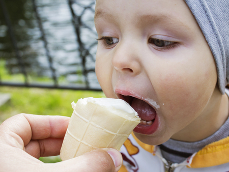 Cute Toddler boy Eating Ice-Cream. kid with dirty face eating ice cream.の写真素材
