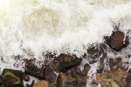 Aerial top view of sea waves hitting rocksの写真素材