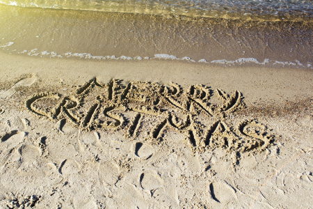 Merry Christmas written on tropical beach sandの写真素材