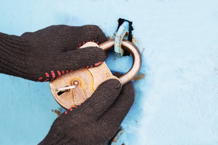 The thief opens the old lock. Safe storage of property