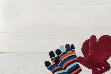 Winter childrens mittens lie on a wooden background