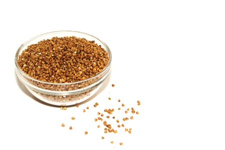Buckwheat in a glass bowl isolated on whiteの写真素材