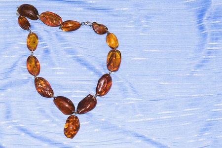 Amber necklace on a light blue background, jewelry made of natural amber.の写真素材