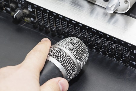 Professional condenser studio microphone over the musician blurred background and audio mixer, Musical instrument Conceptの写真素材