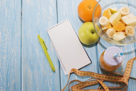 Diet, healthy and active lifestyle concept, apples, bananas, go, tape measure, juice bottle, blank Notepad top view with blank copy spaceの写真素材