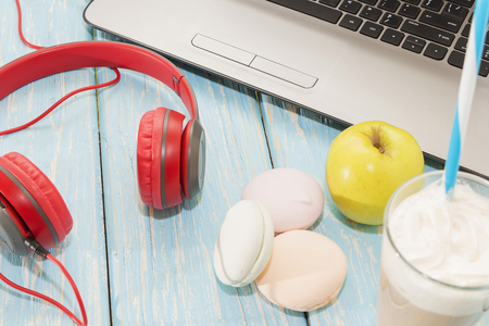 open laptop with white Cup of coffee, marshmallows and red headphonesの写真素材