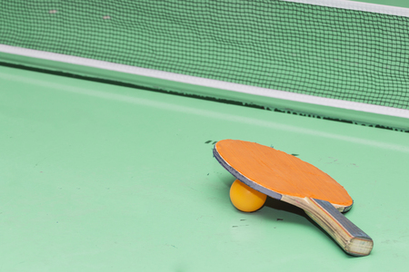 Old table tennis rackets on the game table.の写真素材