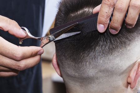 mens hair Styling and grooming with the help of scissors machine and hair clippers in the hair salon.の写真素材