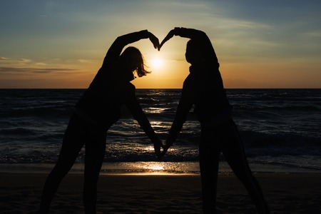 silhouette of two people in love at sunset.の写真素材