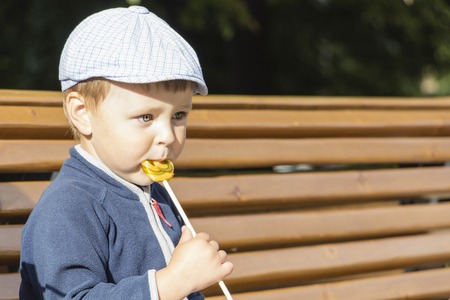 The boy is eating a delicious lollipop.A cute boy licks a lollipop.の写真素材