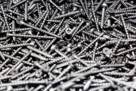 focus on center. black screws texture background closeup, modern metal mix diversity