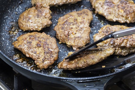 big and juicy cutlet on a metal stand. Home kitchen.