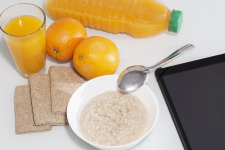 Healty breakfast with muesli, and orange juice. View from above on wooden table with notepad for copy spaceの写真素材