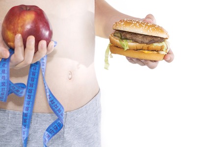 Burger cheeseburger in hands with measure tape isolated on white background. Healthy weight loss diet concept.の写真素材