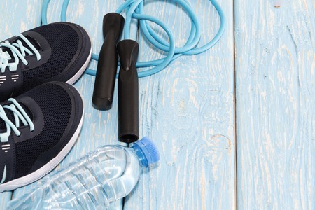 sneakers water bottle, and jump rope on light blue wooden background.の写真素材