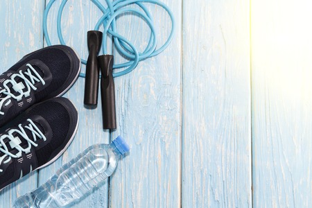 sneakers water bottle, and jump rope on light blue wooden background.の写真素材
