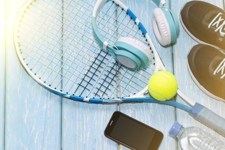 tennis racket. light blue background. sneakers, rocket, ball water bottle music headphonesの写真素材