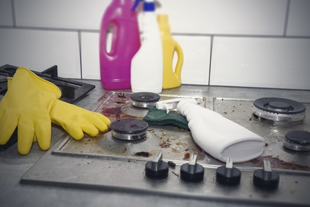 Cleaning a gas stove with kitchen utensils, household concepts, or hygiene and cleaningの写真素材