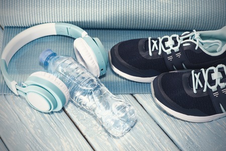 Yoga Mat, sports shoes, water bottle on blue background concept of healthy living, healthy eating, sports and diet.の写真素材