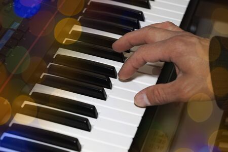 Hands on the piano keyboard electronic organ close-up. Hands of musician play on the pianoの写真素材