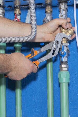 Plumber attaches to pipe gas boiler using adjustable wrenchの写真素材