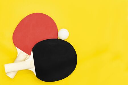 two  table tennis rackets on a bright yellow background