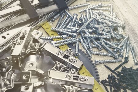 Screws, confirmations for furniture, tape measure, lie on the table. Furniture production.の写真素材